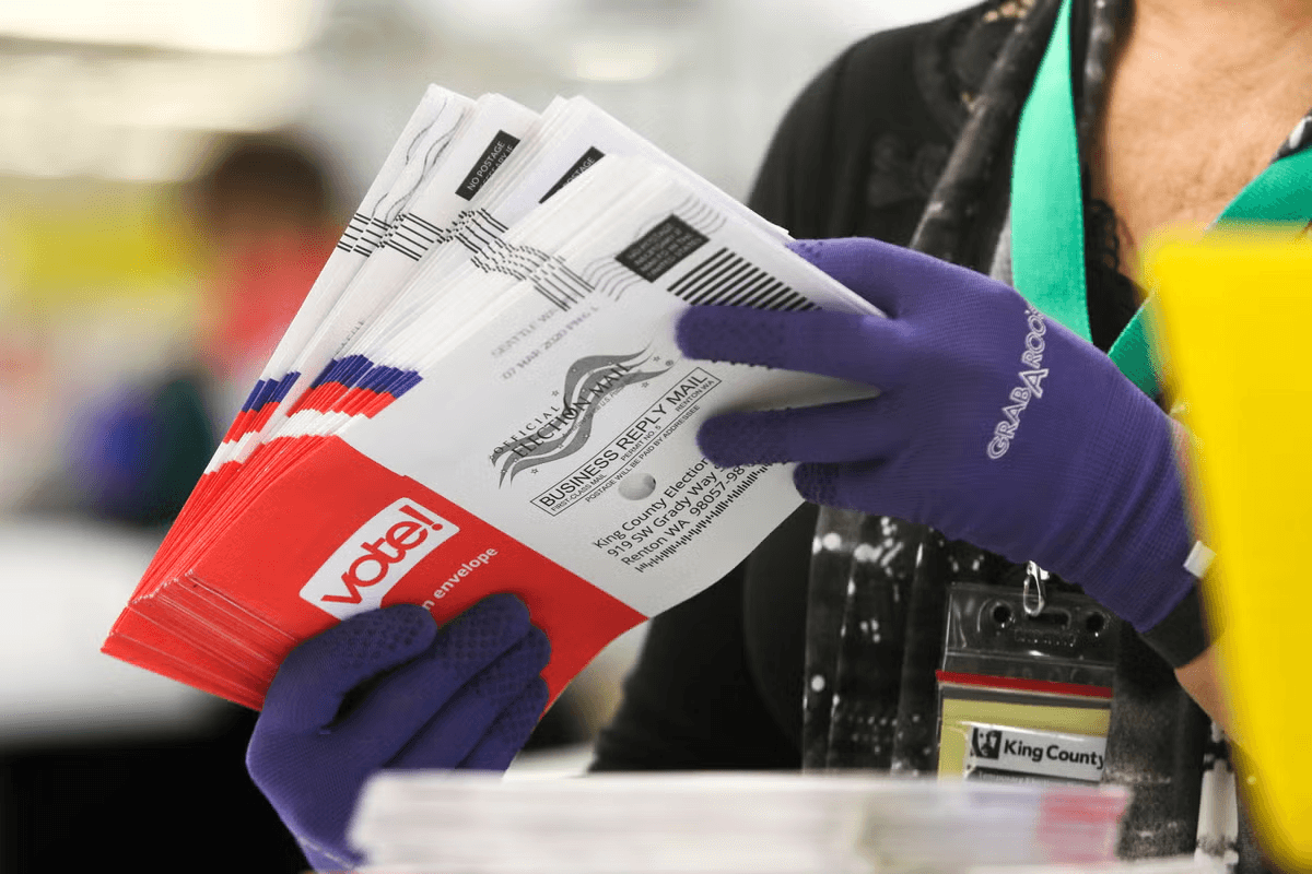Сотрудница избирательной комиссии перебирает бюллетени, полученные по почте, Вашингтон, 2020 год