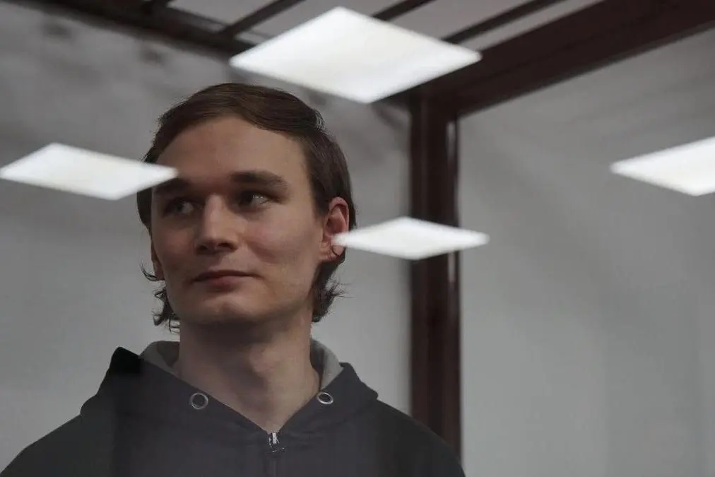 Political prisoner Azat Miftakhov pictured behind the glass of a courtroom holding cell. Photo: Novaya Gazeta