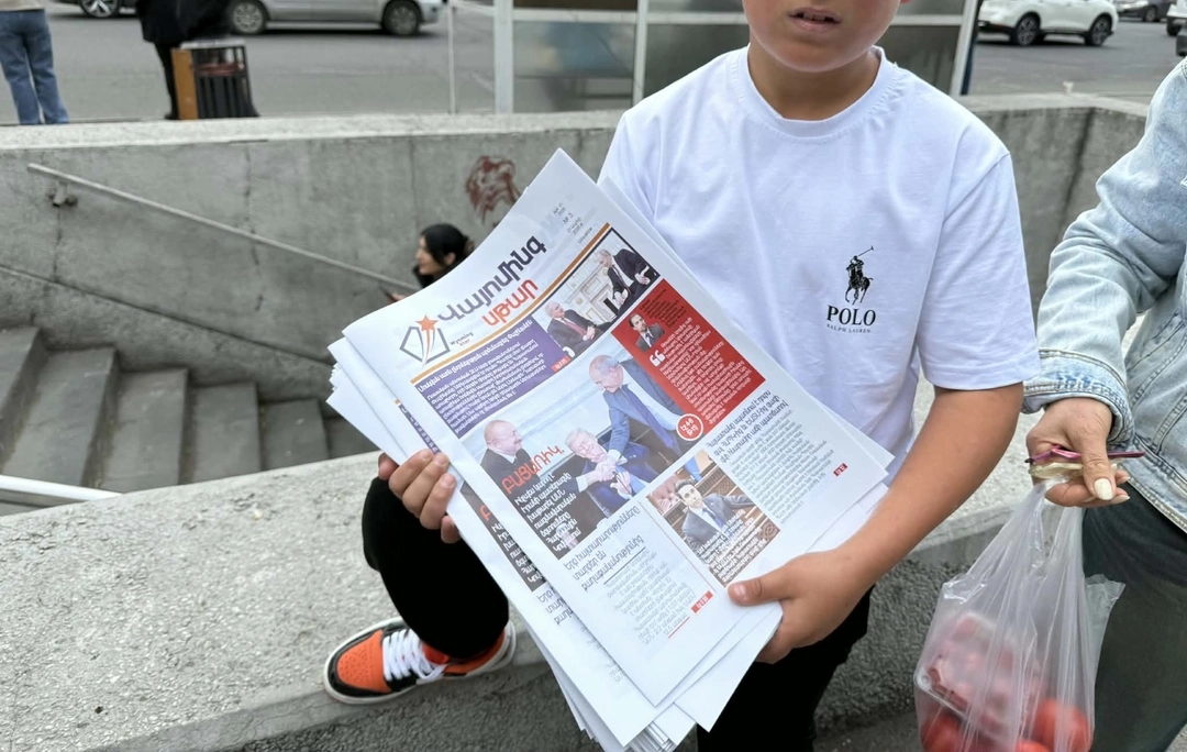 A boy in Yerevan handing out copies of the Wyoming Star